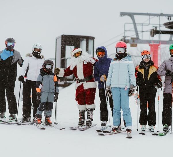 Santa posing with a family at the top of Schuss Mountain