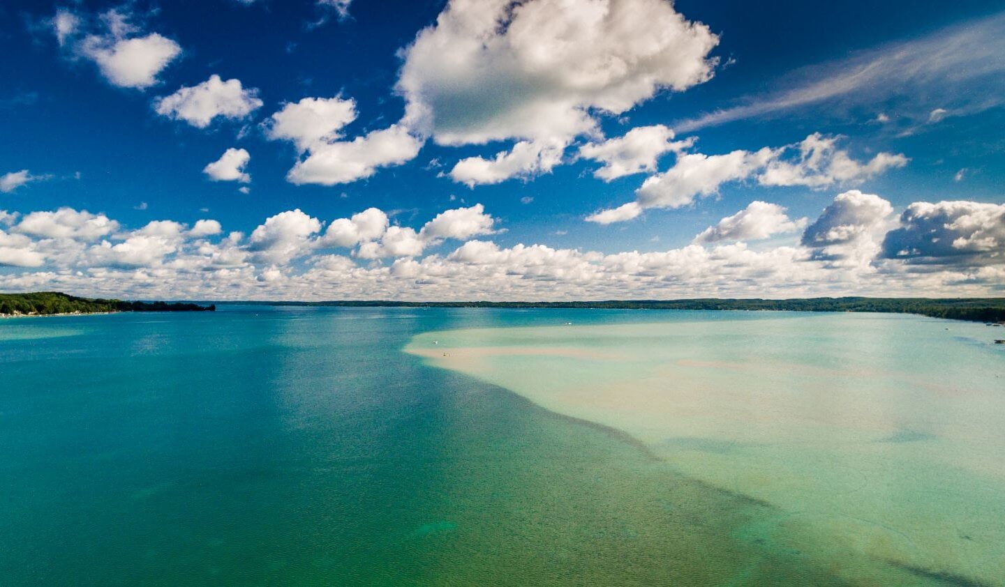 Aerial view of Torch Lake from the south end of the lake. Many different shades of blue highlight the lake's famous sandbar area.