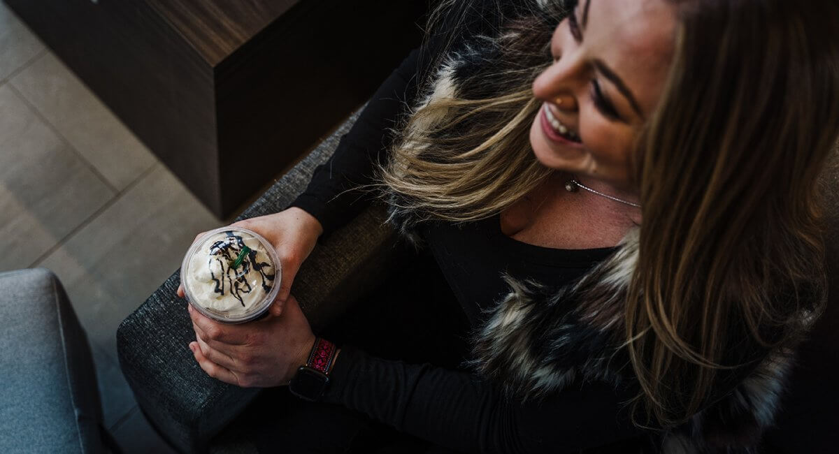 Overhead shot of a woman holding a starbucks drink in the CoffeeBAR