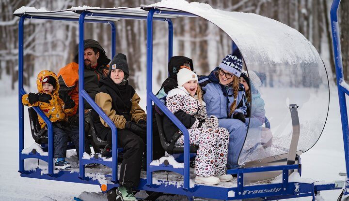 Passengers on the snow glide trailer taking in the sights of Shanty Creek Resort.