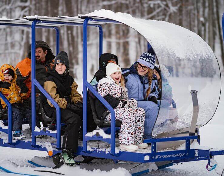 Passengers on the snow glide trailer taking in the sights of Shanty Creek Resort.